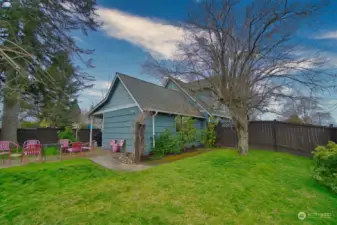 Back yard with mature landscaping, patio area, and shed