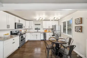 Kitchen with quartz countertops, stainless steel appliances, and eat-in dining space.