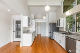 Galley kitchen with new appliances, countertops and cabinets. Walk-in pantry to the back.
