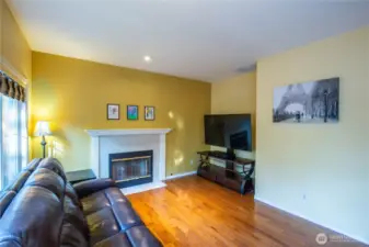 Another view of the family room with beautiful hardwood floors and cozy gas fireplace.