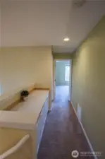 At the top of the stairs is the display and workspace with storage cabinets, leading to the primary ensuite - this is also next to the laundry room and a great place to fold laundry.