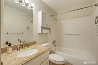 A full bathroom with storage.
