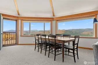 Panoramic dining with views that stretch for miles—an inviting space for memorable meals with family and friends. Patio door opens to fresh air and sunshine, complemented by warm clear fir trim framing every view.