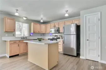 good sized kitchen with island with breakfast bar. Perfect for baking. Pantry is close for storing all those small appiances.