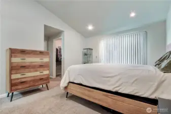 Primary suite is located at the end of the hallway. Sliding door takes you out to the spacious back patio. The room features vaulted ceilings, walk-in closet and bathroom
