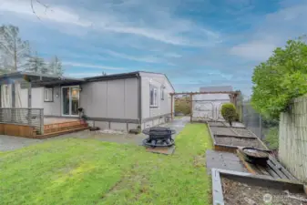 Large side/backyard offering ample space for gardening, a fire pit, and additional outdoor entertaining or storage options