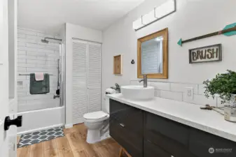 Main floor bathroom with quartz and custom tiled shower.