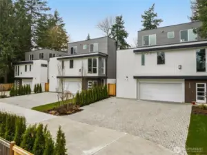 This home seamlessly blends privacy and modern living. Take the architectural charm and greenery from every angle of this inviting residence. Discover the sleek, modern elegance of Tredomas by Shelter Homes. This exterior shot highlights the thoughtful architecture and expansive windows that seamlessly blend luxury and nature, setting the stage for your dream lifestyle.