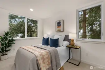 This secondary bedroom is full of charm, with large windows that flood the space with natural light. The stylish decor enhances the cozy, inviting atmosphere, making it the perfect space for guests or a peaceful personal retreat.