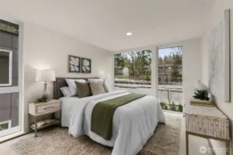 Wake up to peaceful views in this beautifully designed bedroom. Featuring floor-to-ceiling windows and soothing neutral tones, it’s a space that radiates relaxation and warmth.