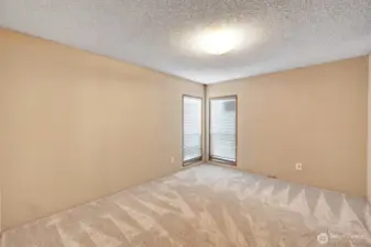 Guest bedroom #2 at the southwest end of the home. Floor to ceiling widows bring in ample natural light. Custom plantation blinds for privacy.