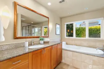 Primary bathroom with granite countertops, jetted tub, and separate shower.