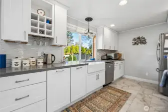 This angle shows off one of the home’s best personality traits, the flow. Warm engineered hardwood carries your eye from the kitchen through the dining room and back toward the front entry, where a large coat closet and bonus drop spot keep the everyday mess politely out of sight. The huge dining room window pulls in light and adds a sense of openness that makes the whole main living area feel bigger than expected.