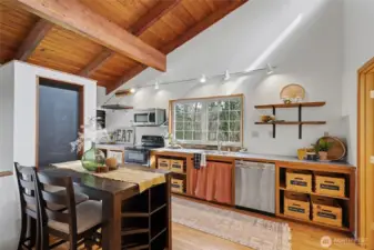 The kitchen is both functional and charming, with generous counter space, open shelving, and a layout that keeps you connected to the living area.