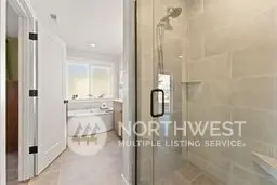 Primary full bathroom with walk in tile shower and 3/4 inch shower door