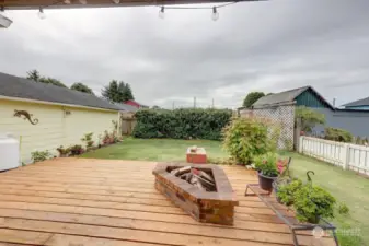 Covered rear deck and fully fenced back yard. Notice the fire pit.