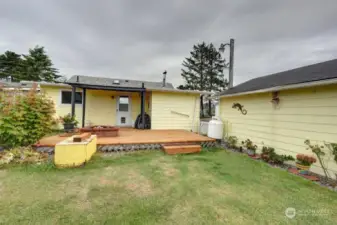 Covered rear deck and fully fenced back yard. Notice the fire pit. The propane tank is for the tankless propane water heater.