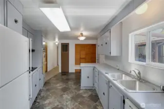 A great Kitchen layout features a dishwasher, refrigerator, counter-top stove, and double-oven!