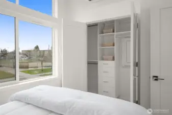 Dual closets with custom built-ins keep everything organized, and use this bright bedroom’s layout extensively.