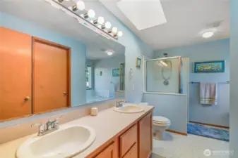Primary bathroom is spacious and has double sinks and a separate shower and tub.