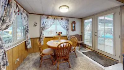 The dining area features large windows that let in ample natural light and access to the new Trex deck!