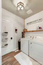 Large utility room with ship lap & faux brick flooring.  Washer & dryer to stay!