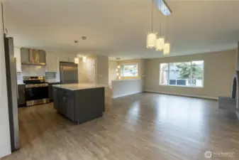From dining room looking into kitchen and living room with fireplace.
