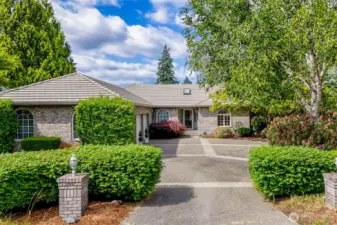 "Classic elegance meets timeless curb appeal in this beautifully maintained brick rambler. The stately facade is complemented by mature landscaping and a sweeping exposed aggregate circular drive—offering both a grand entrance and ample guest parking. Arched windows, manicured hedges, and ornamental details create a welcoming first impression in a truly serene setting."