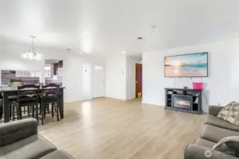 From this view, you can see the front door with a window at the top of it, the kitchen to the left, and the hallway to the bedrooms.