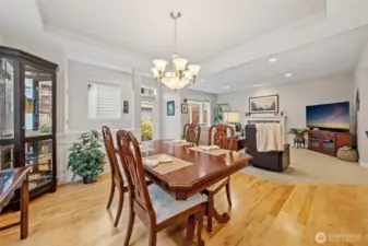 The dining area is filled with natural light and features a box-recessed ceiling that adds depth and architectural interest to the space. Its seamless connection to the living room creates an open, welcoming layout perfect for gatherings and everyday living.