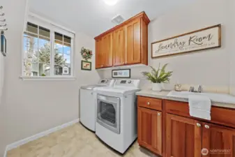 The utility room offers excellent functionality with ample cabinet storage above and below, keeping essentials neatly organized. A convenient soaking sink adds versatility, making laundry tasks and clean-up effortless in this bright, well-planned space.