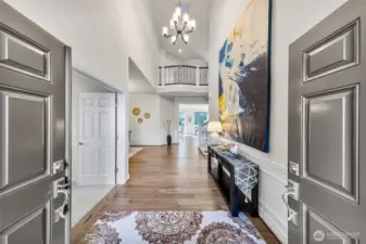 Double door leading to two-story grand foyer with elegant chanderlier.