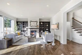 Living room with built in shelves and cozy gas fireplace.