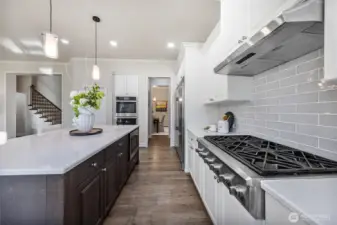Six-burner gas stove and double oven in the kitchen.