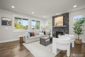 Spacious living room with floor to ceiling stone gas fireplace