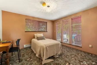 Large primary bedroom has multiple windows and tons of natural light.