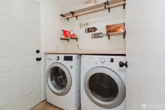 Laundry room with washer/dryer and shelving.