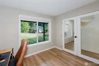 Additional bedroom with laminate floors and large window.