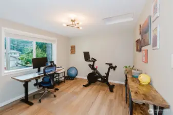 Bonus room staged as a home gym with laminate floors.