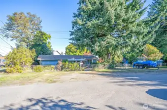Charming corner-lot home with a fully fenced yard, as seen from the street.