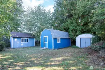 Two outbuilding sheds provide great storage or workspace, one with electrical power for convenience.