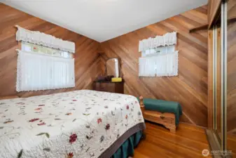 The primary bedroom is on the main floor and has wood-lined walls as well as fir floors.