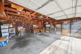 Looking across the two vehicle garage that has an overhead door that opens to the alley.