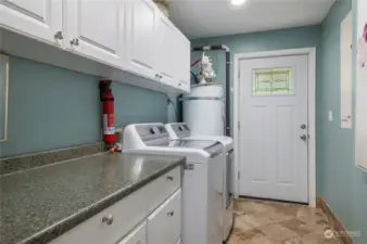 Downstairs laundry room with extra storage, just off the kitchen. Door to backyard.