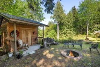 Cute shed and firepit with steps and a paved walkway to the home.