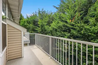 The balcony is just off the living and dining room looking over greenery in a peaceful setting.