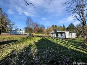 Side view of the home with mature tree, barn, and circular driveway for easy access.