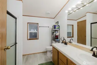 Spacious primary bath with double vanity. New shower door  and flooring