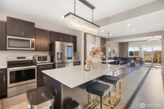 Welcoming island kitchen with stainless steel appliances and quartz counters.