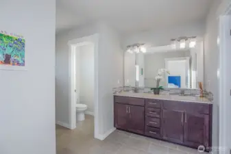 Double sink primary bathroom with water closet.